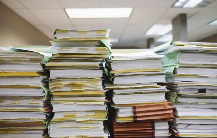 Pilas de documentos y carpetas de archivo sobre un escritorio